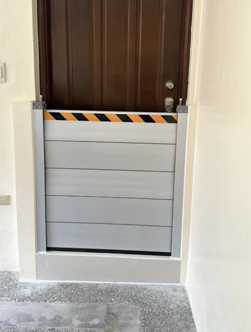 Barrera antiinundación instalada en el hueco estrecho de una puerta de entrada